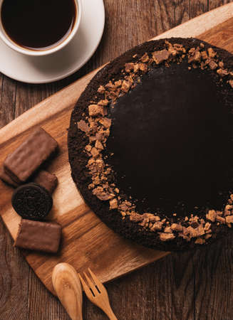 Tasty chocolate frosting cake on wooden tableの写真素材