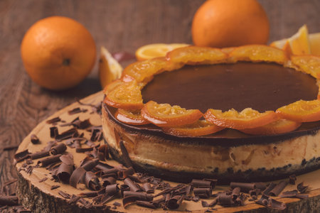 fresh baked delicious orange chocolate cake with slice of orance on top on wood.の写真素材