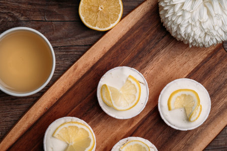 Lemon cupcakes for Easter brunch with yellow lemon and teacup on wood tableの写真素材