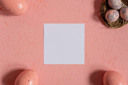 Easter pink background with eggs and card for textの写真素材