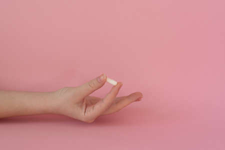 Tablet in female hand, white tablet, pink backgroundの写真素材