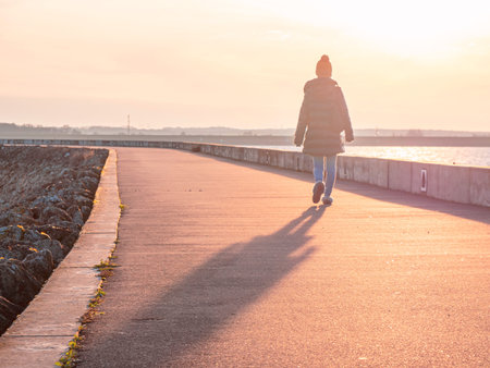 Girl walking on a Pier into the Sunset