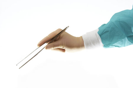 Surgical forceps held by surgeons hand isolated on white
