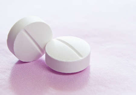 Macro image of two white isolated medicinal tablets の写真素材