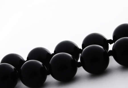 Macro of double string of black shiny pearls isolated on white の写真素材