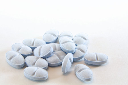Heap of blue medicinal pills or tablets isolated over white background 