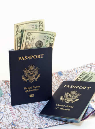 Two American passports with paper money and open map isolated on white background.の写真素材