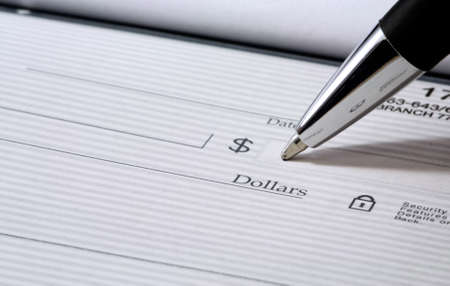 Close up of pen filling out a personal bank check with copy space の写真素材