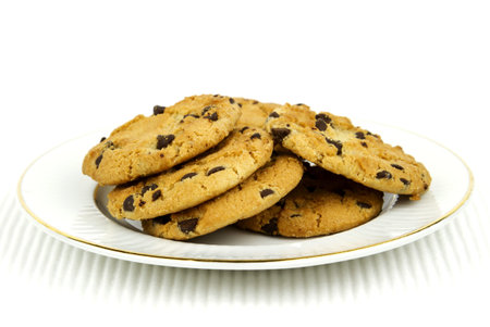 Delicious chocolate chip cookies on white plate against white background with copy space 