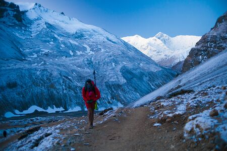Photo young woman traveler with backpack hiking in mountains at sunset. Beautiful landscape on background.の写真素材