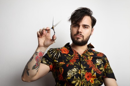 Portrait Handsome Bearded Man Wearing Stylish Shirt Brushing Long Hair Combing.Beauty,Grooming,People Concept Photo.Adult Serious Hipster Guy White Background.Horizontal Photoの写真素材