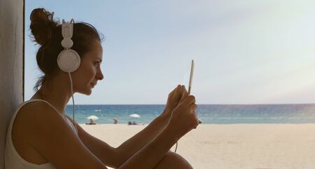 Portrait Handsome Young Woman Listening Music Concert Tablet Headphones Outdoor Beach Background.Pretty Girl Enjoy Audio Smiling Closed Eyes.Beauty Lifestyle Fashion Hipster People Summer Concept.Sunの写真素材