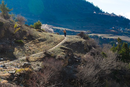 Nepalese Sherpa Hiking Mountain Trail Village Path.Young Man Climbing Loaded Bags Track Traveler Beautiful Noth Asia.Summer Landscape Background.Horizontal Photoの写真素材