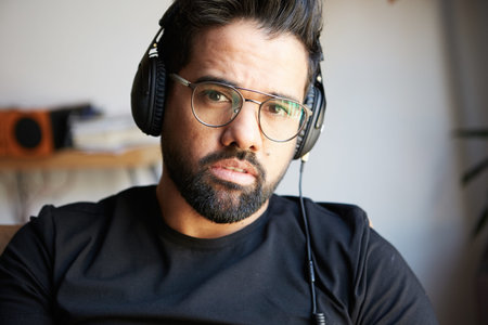 Portrait of handsome bearded man in headphones listening to music at home. Relaxing and rest time...