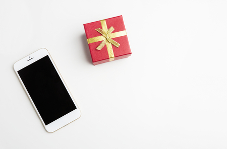 Mockup of smartphone, gift box on empty white clean desk. Business mock-up background for message writing.Top view. Horizontalの写真素材