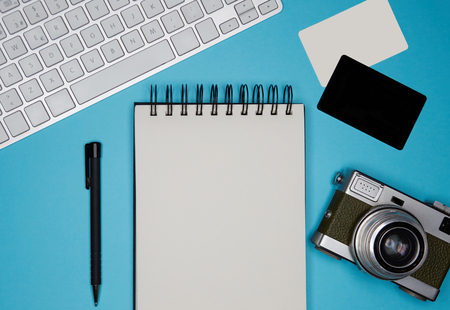 Mockup of two blank business cards, paper note book, computer keyboard on empty color desk. Business empty mock-up background for message writing.Top viewの写真素材