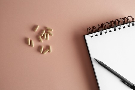 Overhead view of medical doctor office desk with note pad clipboard and prescription drugs. Horizontalの写真素材