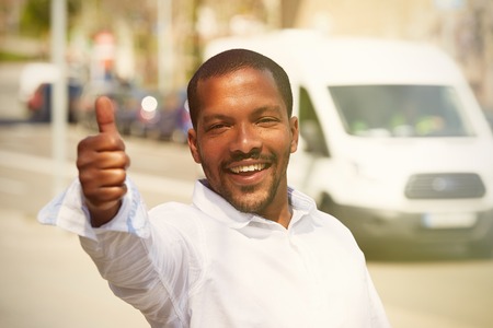 Portrait of attractive young African-American businessman in white shirt showing hand symbol Okeyの写真素材