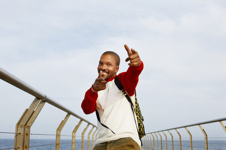 Smiling young African-American hipster enjoing summer vacation on the beach outside of the city