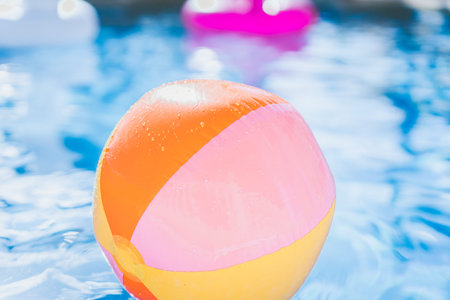 colorful Beach ball floating in swimming pool. Abstract concept of summer vacations, relaxation and...