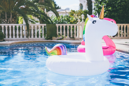 Inflatable colorful white unicorn at the swimming pool. Fun time in the Summer at swimming pool. conceptの写真素材