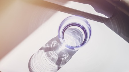 One glasses of water on sunny wooden table. Top viewの写真素材