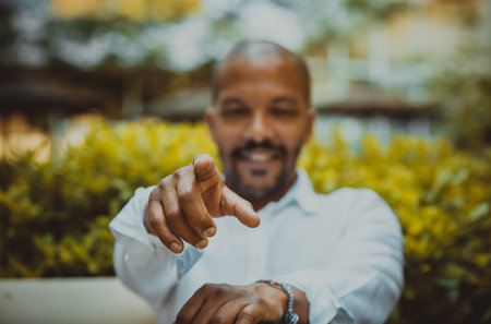 American african confident businessman in white shirt pointing hand to camera and smiling outside...