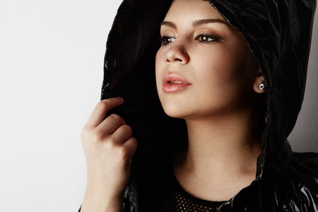 Portrait of fashion beautiful brunette girl wearing black leather jacket with fresh daily makeup posing over white empty background.Positive woman emotions, reaction, gestures.Fashion female conceptの写真素材