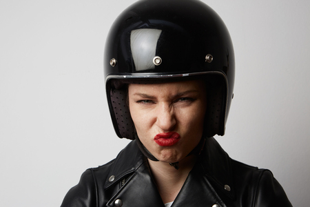 Headshot Portrait of sexy girl with red lips in black leather jacket smiling looking at camera. White background. Fashion, glamour and emotions conceptの写真素材