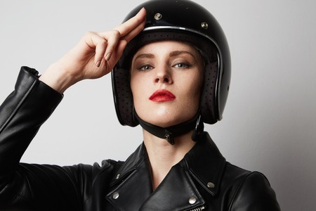 Headshot Portrait of sexy girl with red lips in black leather jacket smiling looking at camera. White background. Fashion, glamour and emotions conceptの写真素材
