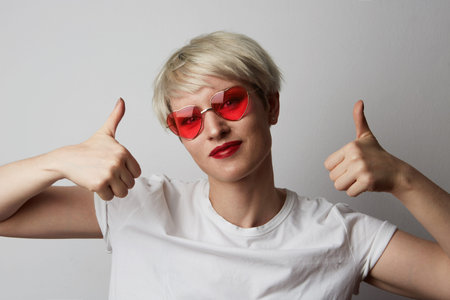 Portrait Happy young blonde woman with short hair over empty white background.Girl showing ok sign and smiling.Positive human emotions, reaction, gestures and body languageの写真素材