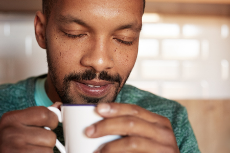 African american black man holding cup of coffee at home. Closeupの写真素材