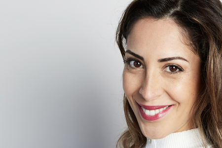 Monochrome shot of happy caucasian businesswoman with positive smile, has crisp dark hair, isolated on white wall background.の写真素材