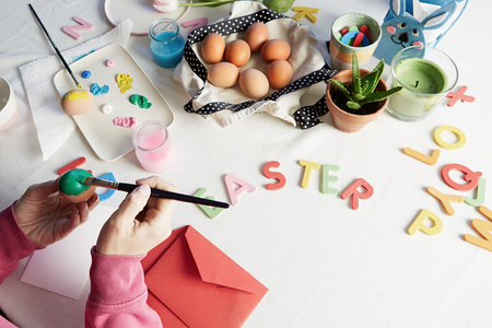 Happy easter. Young woman painting easter eggs. Happy family preparing for Easter.の写真素材