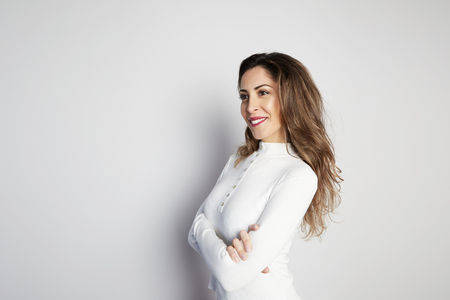 Monochrome shot of happy caucasian businesswoman with positive smile, has crisp dark hair, isolated on white wall background.の写真素材