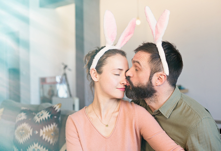 Happy and funny easter day. Beautiful young loving couple wearing rabbit bunny ears costumeの写真素材