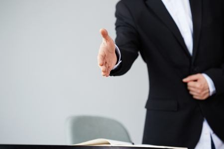 Confident young asian businessman offering handshake after business deal