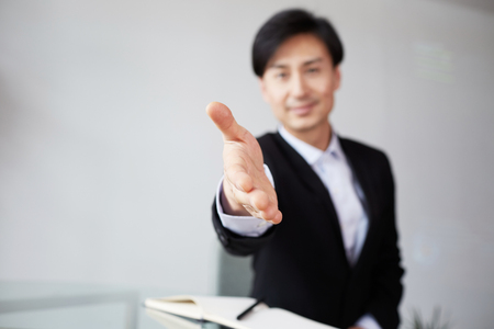 Confident young asian businessman offering handshake after business dealの写真素材