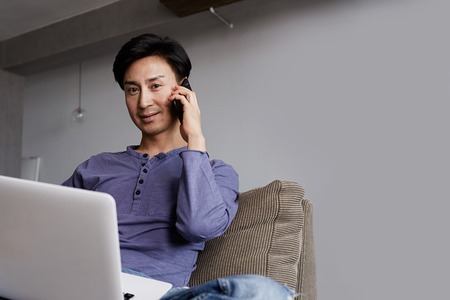 Handsome gay Asian Man Working Laptop Home Connecting Networking Concept.の写真素材