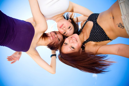 girls friends having fun during summer time under sunny blue sky の写真素材