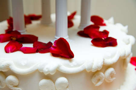 wedding cake with red rose petals as decorationの写真素材
