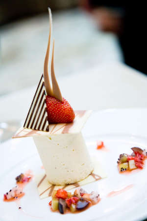 a plate of ice cream dessert served with chocolate and strawberryの写真素材