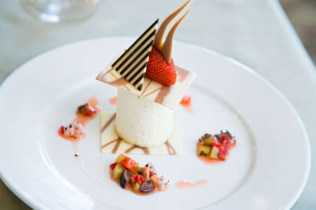 a plate of ice cream dessert served with chocolate and strawberryの写真素材
