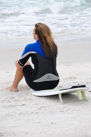 ANNA MARIA ISLAND, FLORIDA/USA - OCTOBER 18:  Young female surfer resting on her surfboard while surfing in the Gulf of Mexicoのeditorial素材