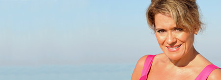 Attractive Woman on Beach in a Summer Dress. Horizontal Banner with Copy Space.の写真素材