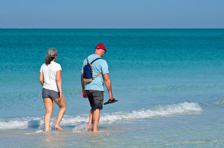 Unidentified Couple on vacation taking a walk on the beach  and enjoying a beautiful sunny day on...