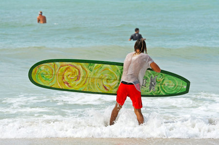 HOLMES BEACH, ANNA MARIA ISLAND, FL / USA -  October 4, 2013: Surfers on Anna Maria Island taking...