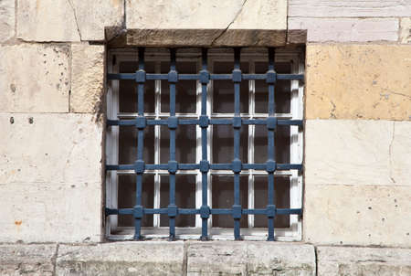 Window with bars in an old stone building.
の写真素材