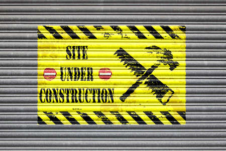 Metal shutter with site under construction painted sign.の写真素材