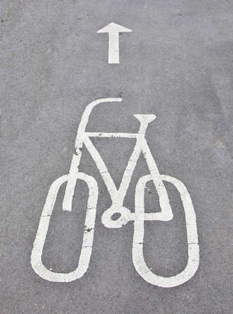 Painted Bicycle symbol and arrow on a tarmac cycle pathの写真素材